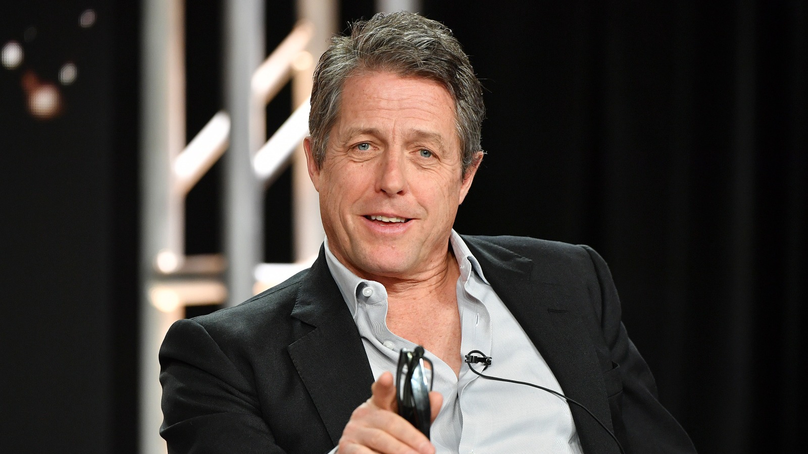 Hugh Grant speaks on a microphone