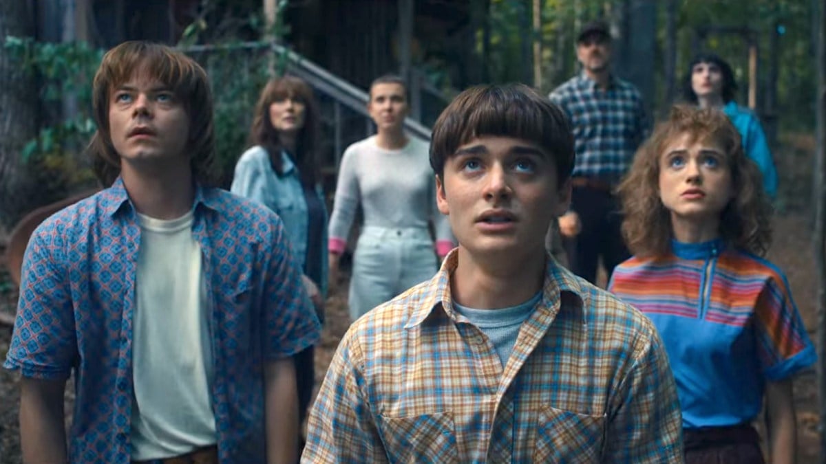 The cast of ‘Stranger Things’ look nervously skyward outside Hopper’s cabin