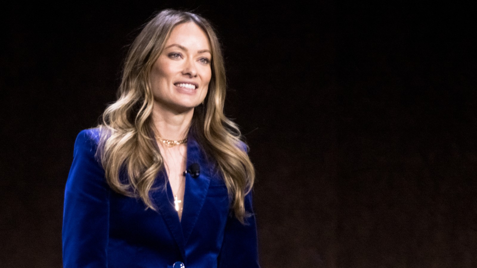 Olivia Wilde wears a velvety blue blazer during a presentation.