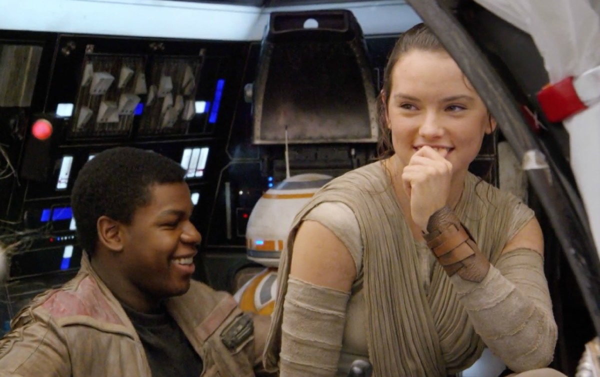 John Boyega and Daisy Ridley in costume for “Star Wars: The Force Awakens,” laughing