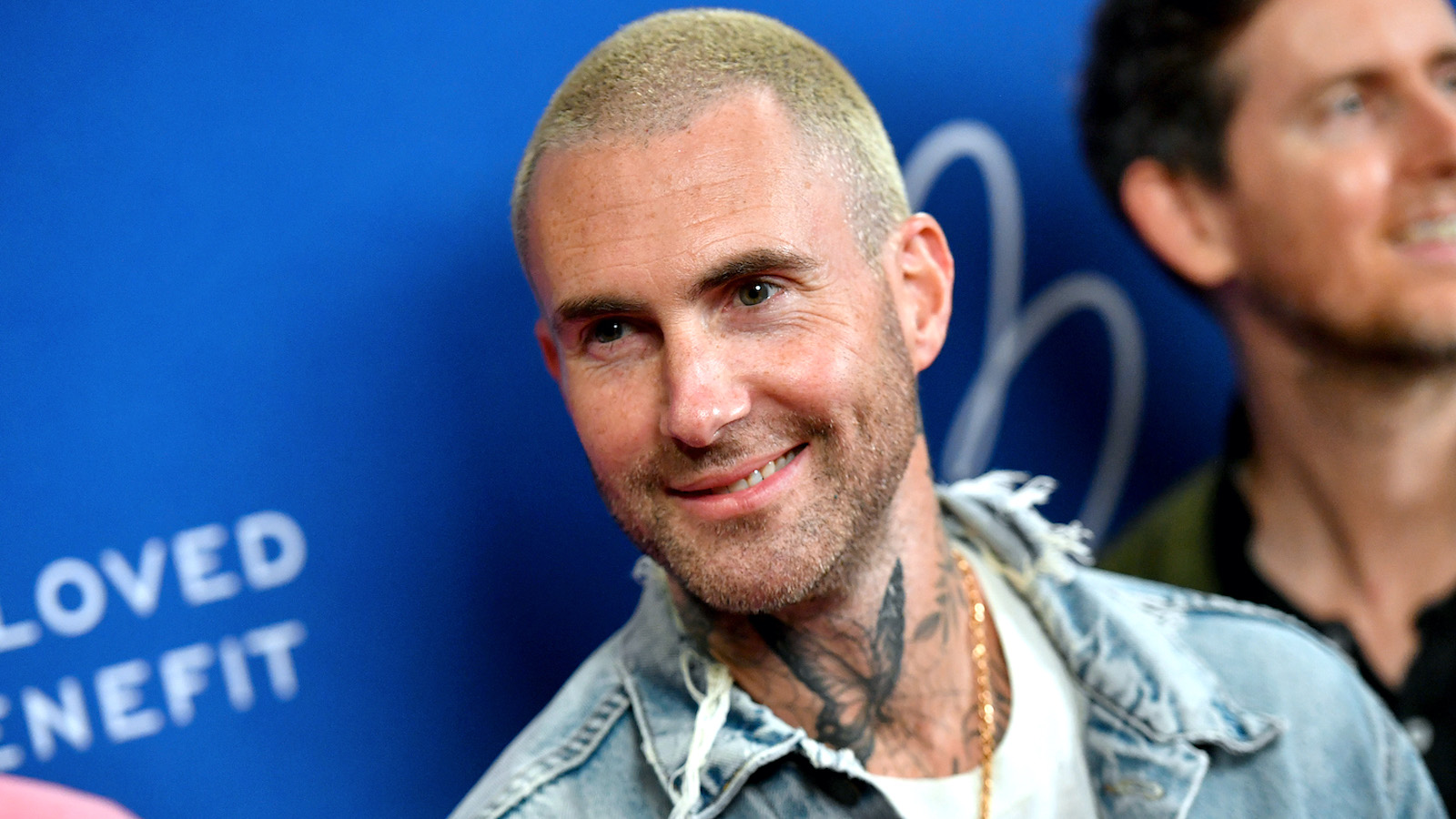 Adam Levine wearing a denim jacket and sporting a blonde buzz cut