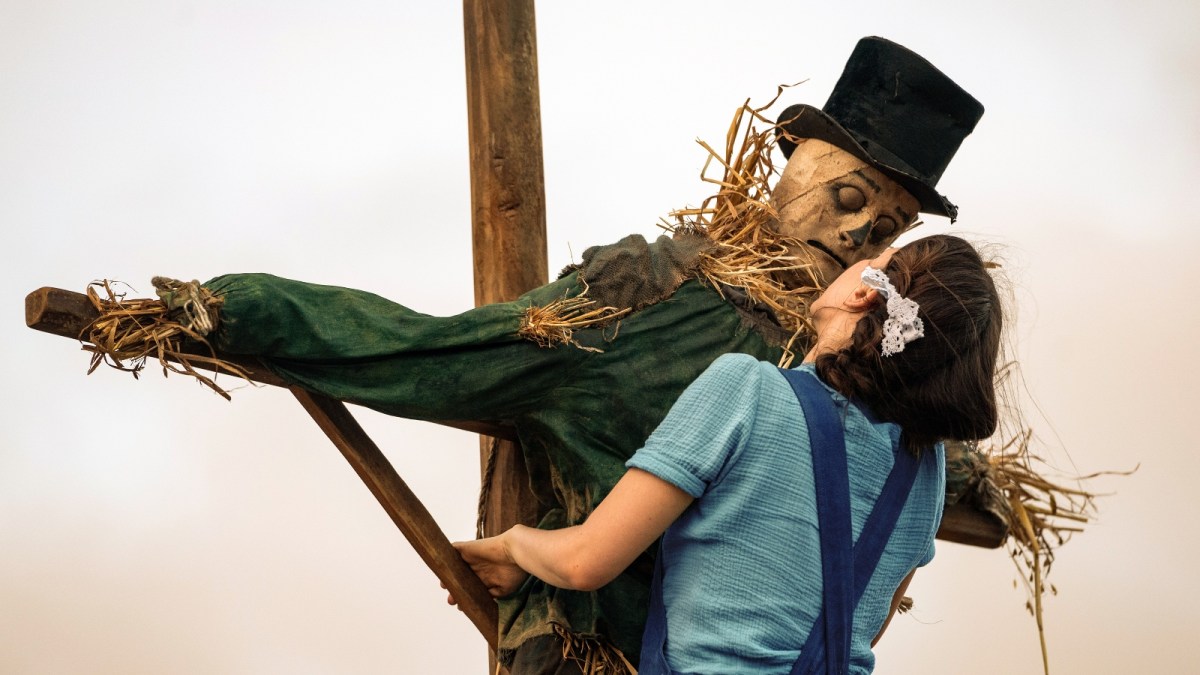 Mia Goth as Pearl hugging a scarecrow