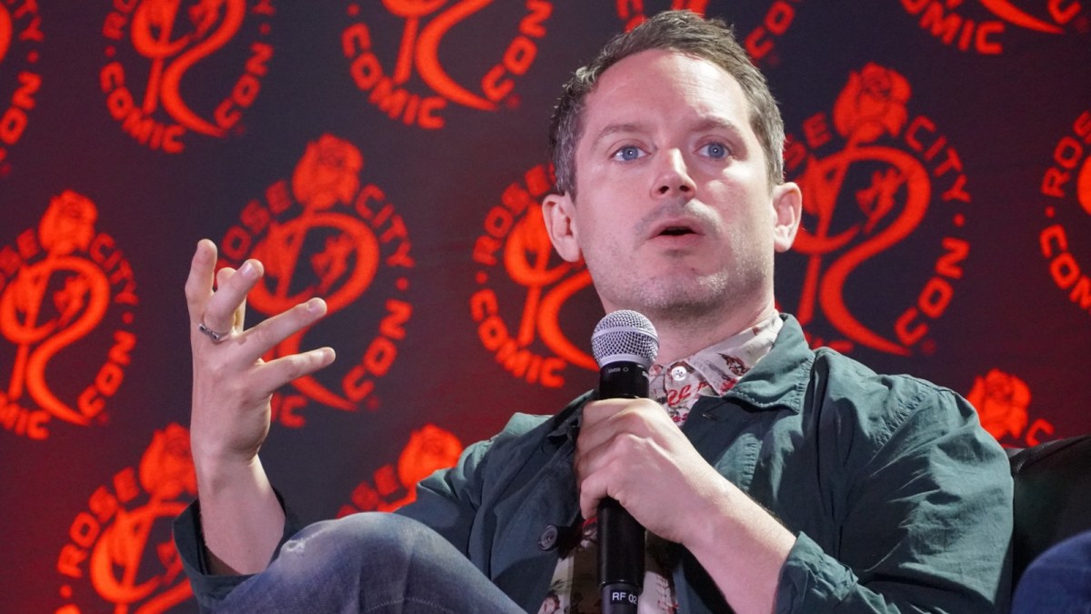 Elijah Wood gives a talk at a comic con panel.