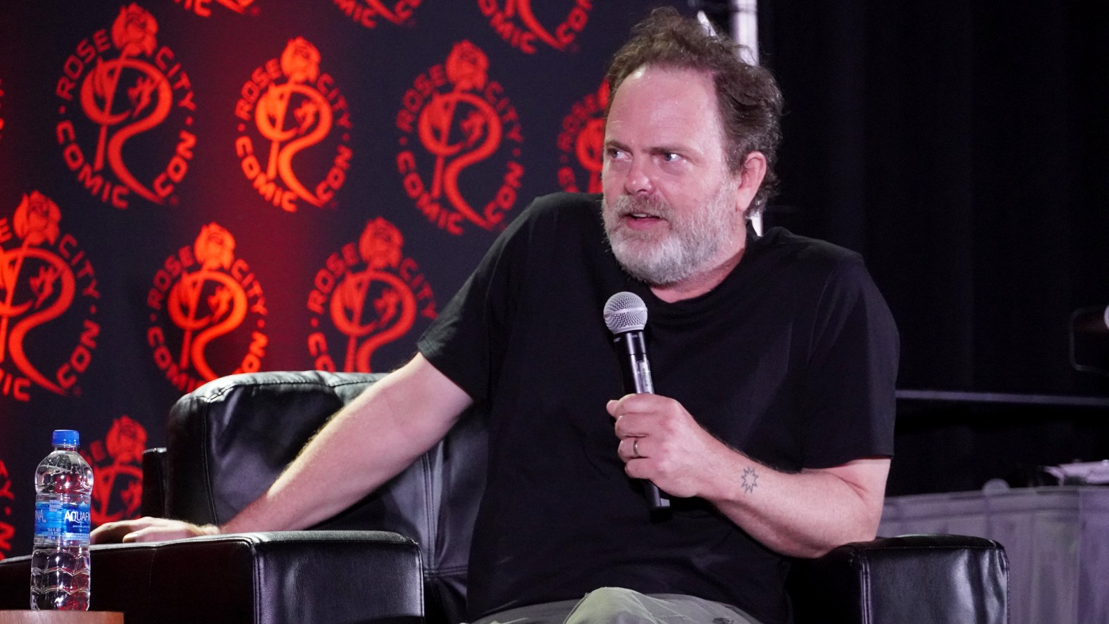 Rainn Wilson gives a talk at a fan event.