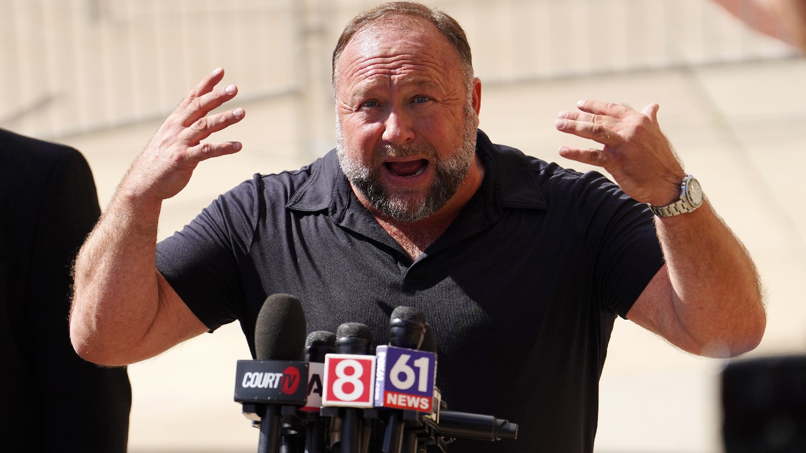 Alex Jones makes a speech outside a courthouse.