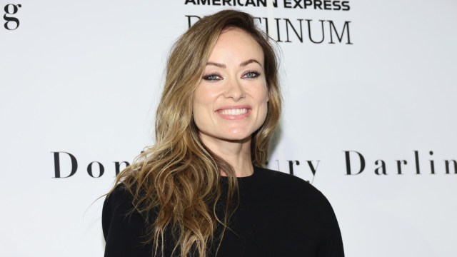 Olivia Wilde flashes a smile at a red carpet event.