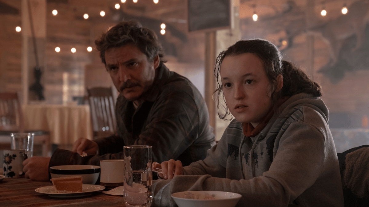 Ellie (Bella Ramsey) and Joel (Pedro Pascal) eating a meal in the Jackson cafeteria