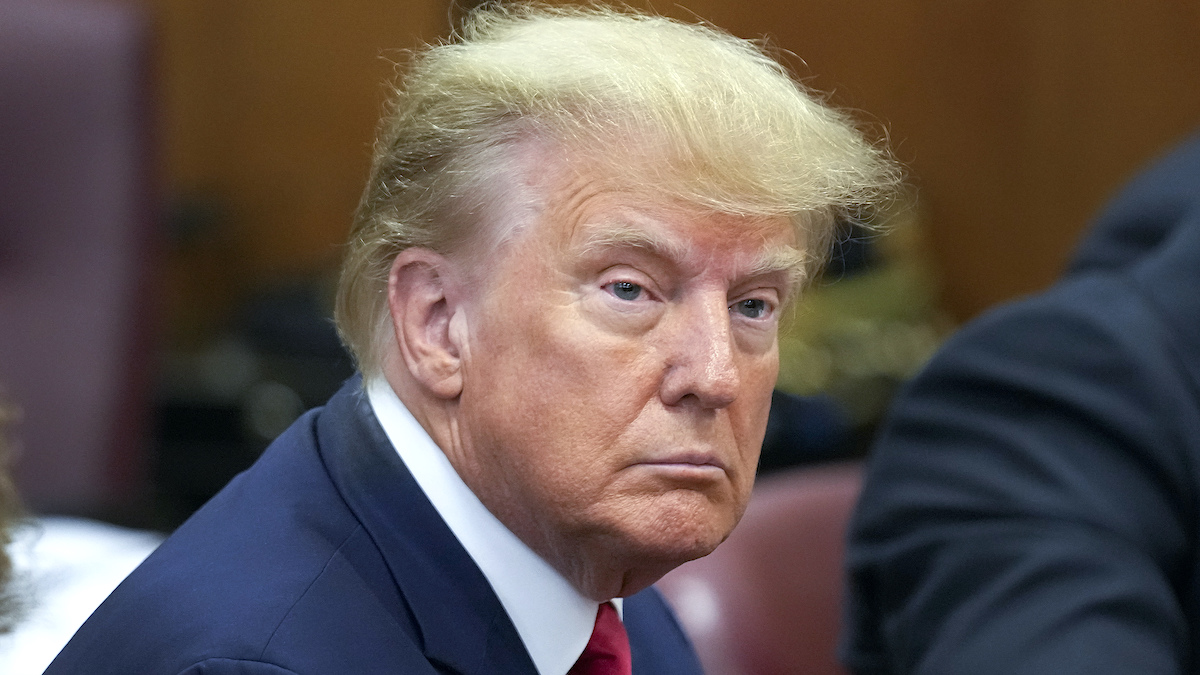 Former President Donald Trump sits at the defense table