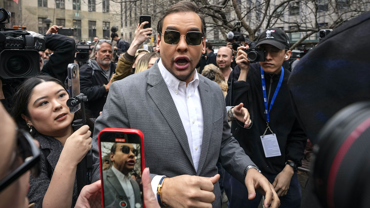 George Santos in a crowd full of people with cell phone cameras pointed at him