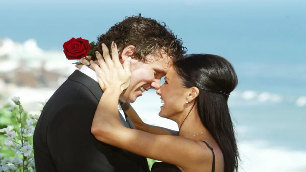 Bob Guiney's face is being held by a woman holding a rose.