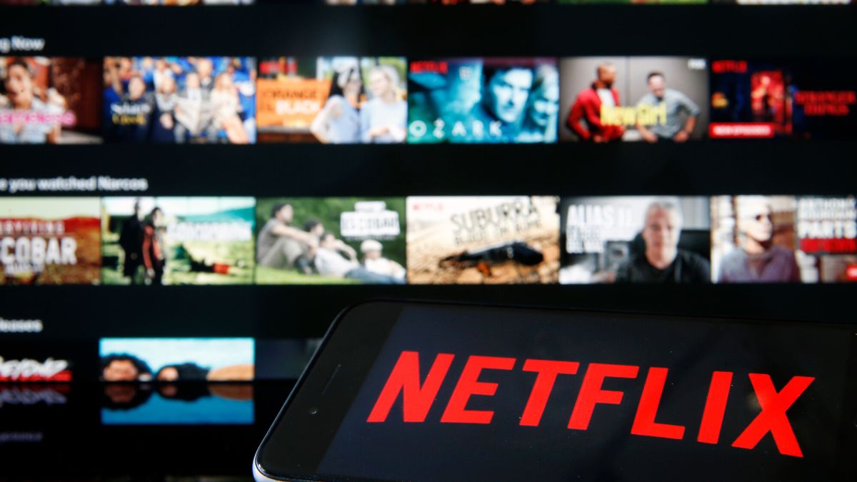 PARIS, FRANCE - MARCH 28: In this photo illustration, the Netflix media service provider's logo is displayed on the screen of an iPhone in front of a television screen on March 28, 2020 in Paris, France. Faced with the coronavirus crisis, Netflix will reduce visual quality for the next 30 days, in order to limit its use of bandwidth. 