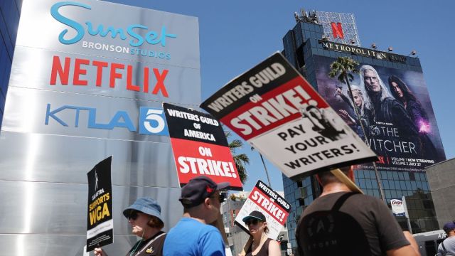 LOS ANGELES, CALIFORNIA - JULY 11: People carry signs as SAG-AFTRA members walk the picket line in solidarity with striking WGA (Writers Guild of America) workers outside Netflix offices on July 11, 2023 in Los Angeles, California. Industry insiders concerned about the possibility of a potential actors’ strike will have to wait a little bit longer to know for sure. SAG-AFTRA and top studios and streamers have agreed to extend their current contract negotiations until July 12 at 11:59 p.m.