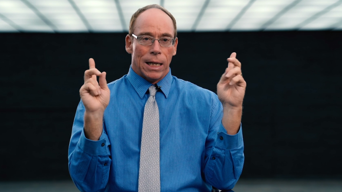 Steven Greer pointing to the ceiling with both hands