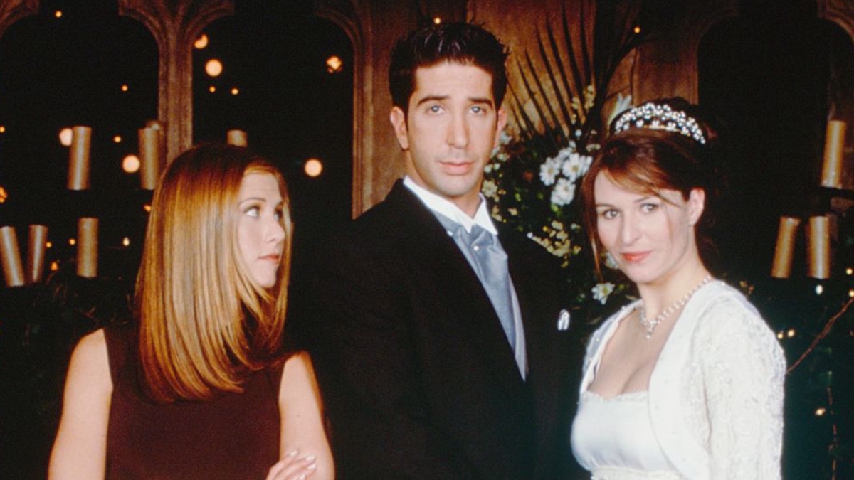 Ross and Emily pose together for their wedding picture, while Rachel looks back at them.