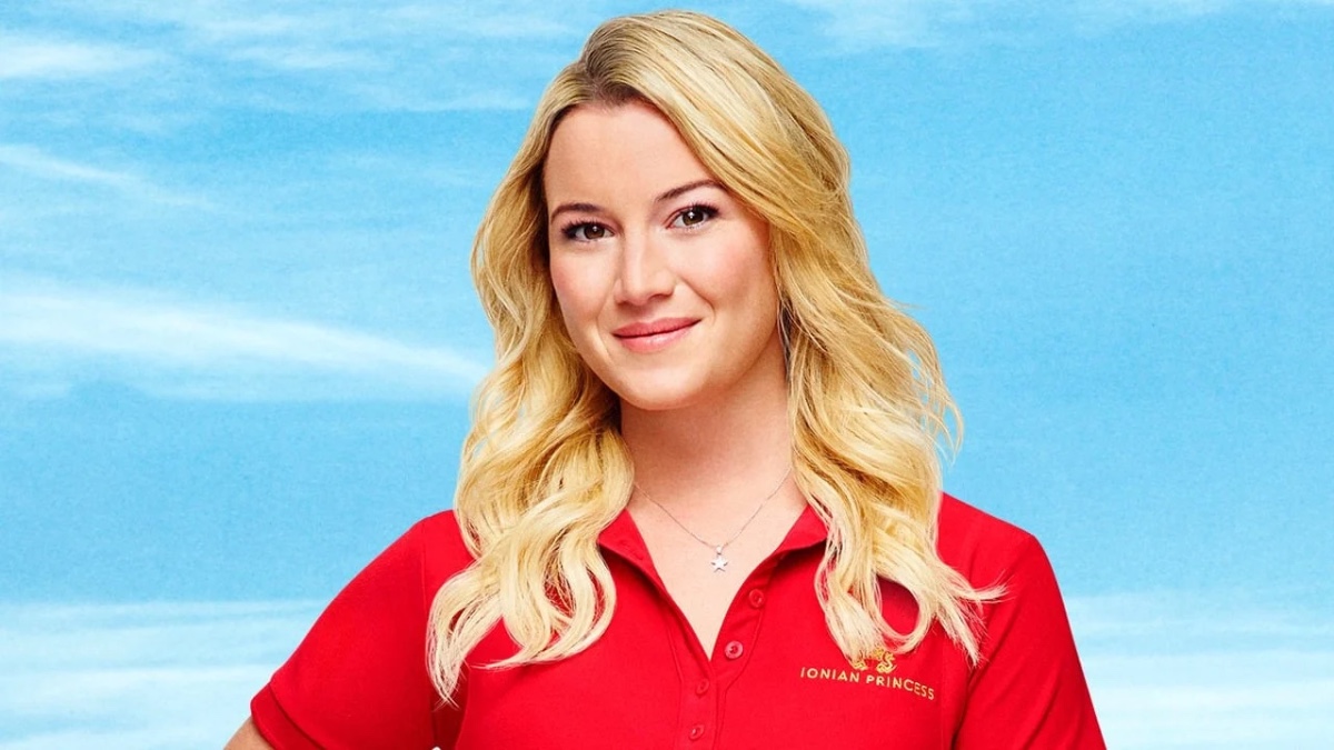 Hannah Ferrier in red polo smiling against a blue background