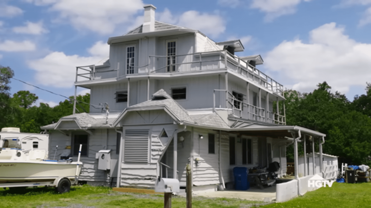 A white three-storey house that resembles a rickety ship. 