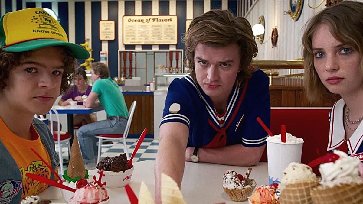 'Stranger Things' characters Dustin (Gaten Matarazzo), Steve (Joe Keery), and Robin (Maya Hawke) looking intimidatingly at the camera during a scene set at ice cream parlour Scoops Ahoy from the show's third season.