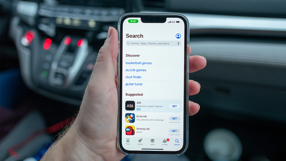 Person's hand holding the Apple iPhone 13 Pro in an automobile, Lafayette, California, with screen showing the App Store