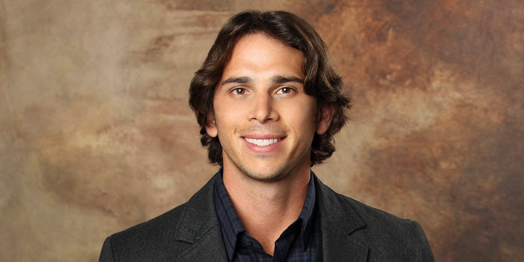 Ben Flajnik is standing in front of a brown, textured background.